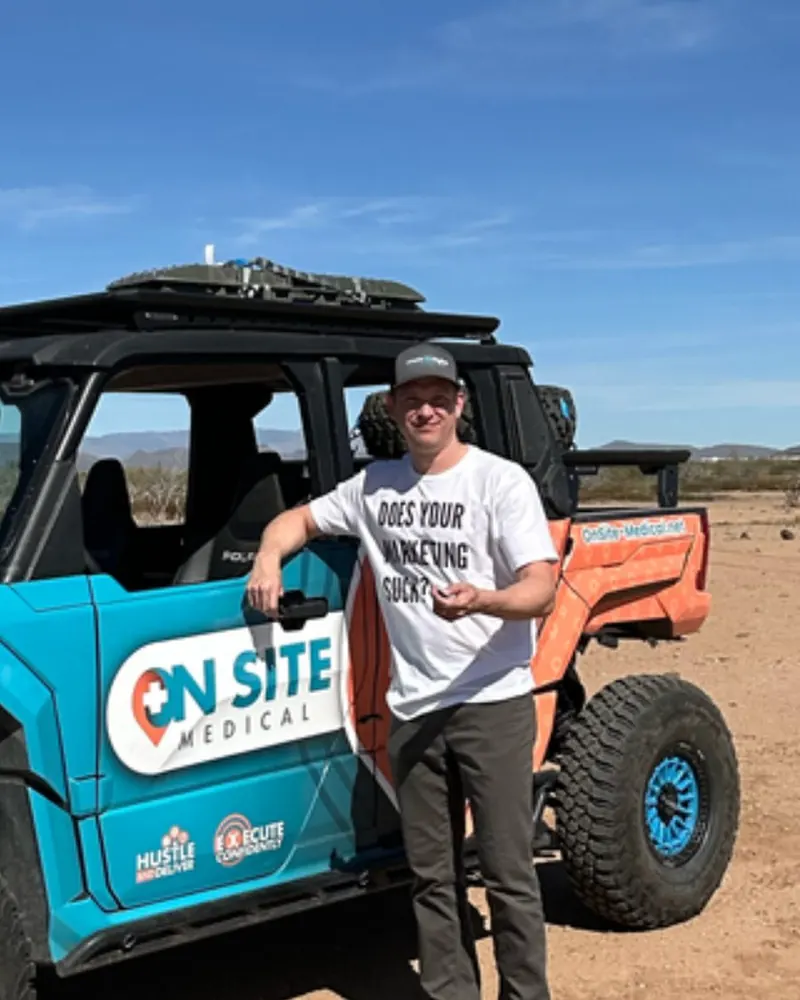 Brandon leaning on the On Site Medical off-road rig in the Arizona desert